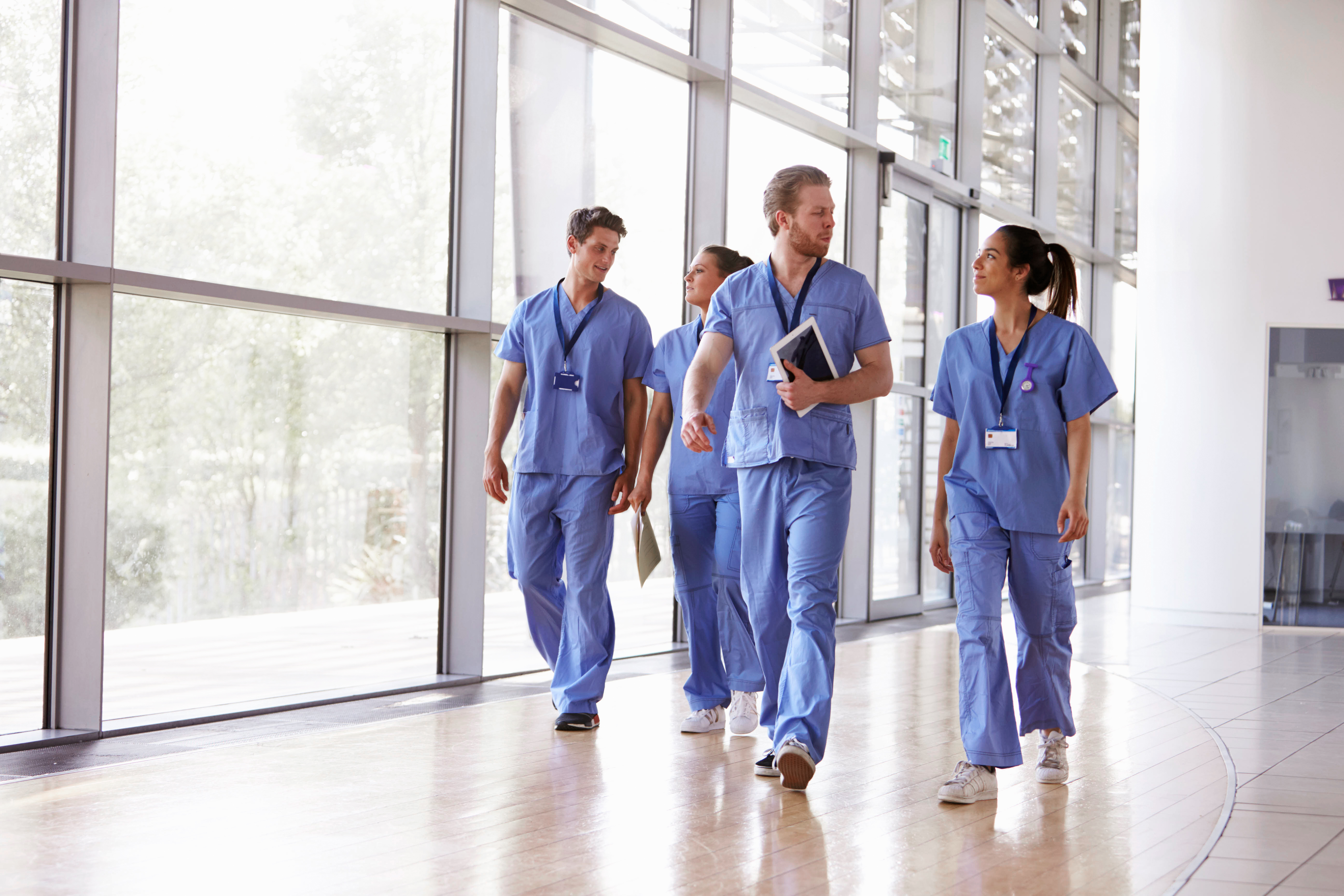Nurses walking down a hallway, talking to each other